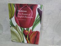 Front cover of the book 'Sanderson The Essence of English Decoration' showing large floral artwork with tulips and green leaves.
