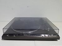 View of the Technics SL-B200 turntable with closed transparent dust cover, showing the entire unit from the front.
