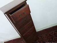 Angled view of dresser with one drawer partially open showing drawer construction and metal handles.