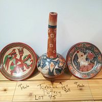 Front view of the lot with two 9-inch Tonala plates and one 15-inch tall vase, labeled with dimensions on the shelf
