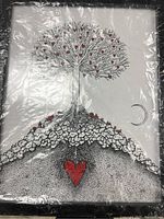 Full view of framed family tree artwork showing the tree with red heart-shaped leaves and a large red heart at the base with surface textures and a crescent moon.