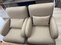 Front view of both matching chairs showing upholstery, pillows, armrests and legs