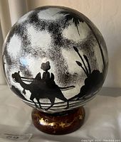 Front view of Moroccan lamp shade globe showcasing camel silhouettes against a frosted glass sphere with decorative brown base.