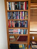 Full view of bookshelf with multiple shelves holding a variety of hardcover books including uniform Time-Life series and mixed popular fiction and non-fiction titles.