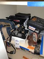 Overall lot on shelf showing cameras, lenses and cases