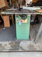 Full view of green Grizzly table saw on pedestal