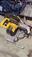 Full view of DeWALT DW705 12-inch compound miter saw showing the yellow and black body and metal base.