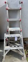 Full view of Franklin 17-foot multi-task telescoping aluminum ladder, with red accents, showing general condition including some rust and fading