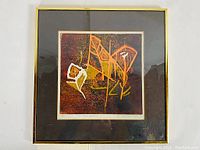 Full view of the framed print with dark mat and gold frame under glass.