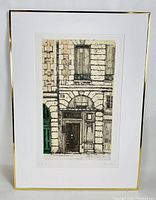 Front view of framed engraving print showing detailed architectural building facade with signature visible in lower margin.