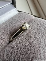 Close-up view of front of ring showing round diamond in six-prong setting