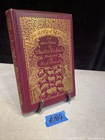 Front cover of the hardcover book with gold embossed title and illustrations on a maroon background.