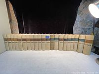 Photo of 21 vintage law books arranged in chronological order from 1942 to 1962 with beige spines.