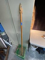 Full length photo of the solid wood walking stick with a carved howling wolf or dog figure at the top.