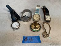 Image showing six vintage watches of various styles and bands laid out on a surface, with a blue tag marked '#16'