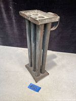 Full view of antique primitive candle mold standing upright showing four cylindrical molds and attached handle