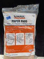 Photo of eight new U-Haul paper pads in original packaging showing label and usage instructions.