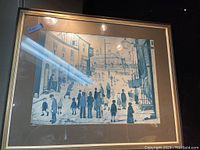 Framed print showing urban street scene with people and buildings