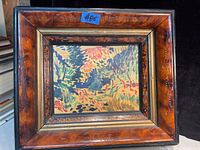 View of unsigned colorful abstract landscape painting on board in antique wood frame showing details of frame and artwork.