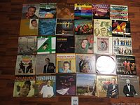 Photo showing all 30 LP vinyl record covers neatly arranged on wooden floor showing varied artists and genres