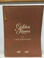 Front cover of the book showing title 'Golden Leaves from Canada's Past 1867-1967' with decorative maple leaf illustrations and gold tassel on spine.
