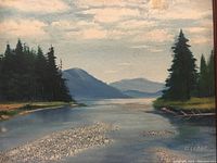 Close up of the oil painting showing the landscape scene with river, trees, mountains, and sky, signature visible.