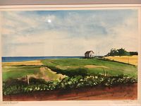 Framed original watercolor painting showing coastal landscape with fields, house and ocean, signed by artist and dated 1990 in lower corners.
