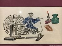 Close-up of the color rubbing artwork featuring a person at a spinning wheel and objects.