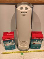 Front view of white Honeywell tower humidifier with two boxed filters placed on each side.
