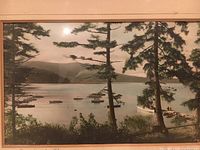 Close-up view of the vintage color photograph showing boats in Brentwood Bay with pine trees in foreground and mountain in background.