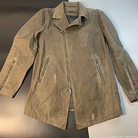 Front view showing quilted sleeves, asymmetrical zipper, and visible oil stains on front and sleeves