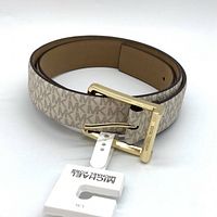 Coiled Michael Kors MK logo pattern belt with gold buckle and attached Michael Kors tag.