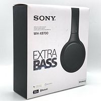 Front and left side view of the boxed Sony WH-XB700 headset showing model, branding, extra bass text, and wireless features.