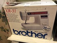 Box front with image of the Brother XR-31 free arm sewing machine and branding, showing 25-year limited warranty.