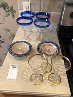 Photo showing four margarita glasses with blue rims and two terracotta apple bakers on kitchen counter.