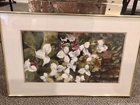 Framed watercolour painting showing full artwork of white flowers and surrounding foliage in green, brown, and purple hues.