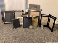 Full lot showing 20 picture frames of various styles and sizes plus the photo storage box.