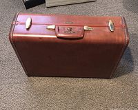 Full view of vintage brown leather Samsonite suitcase showing shape, hardware, and overall condition