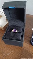 Ring displayed in presentation box, showing overall appearance and stone color