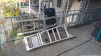 Aluminum extension ladder laid horizontally with multiple rungs, showing metal construction and some wear marks.