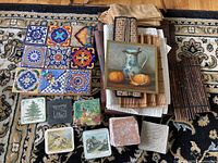 Overview of all items including tile trivets, fabric napkins, bamboo placemats, coasters, and wooden trivets arranged on patterned carpet