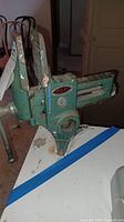 Photo showing the full vise mounted on a table edge with visible wear and paint chipping.