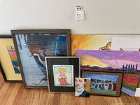Group shot of six artworks leaning against wall