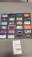 24 GBA cartridges arranged in grid on flat surface with lot card