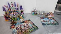 Both LEGO Elves sets fully assembled with instruction manuals placed in front of them.
