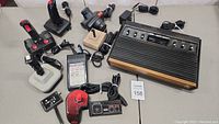 Photo of Atari 2600 console with six different controllers placed around it.