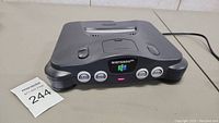 Front view of the Nintendo 64 console showing four controller ports and the power indicator light on.