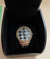 Photo showing the watch face inside a black cushioned watch box.