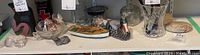 Shelf with various assorted decorative items including figurines, shells, small rocks, glass vase, and model boat.