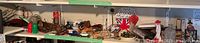Shelf with various figurines, vintage toys, and collectibles including a Union Jack item and small shoes.